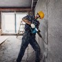 Handwerker mit Bosch Professional Bohrhammer GSH 5 CC beim Stemmen einer Wand.