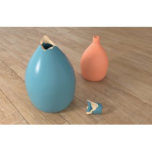 Beschädigte blaue Vase und intakte orangefarbene Vase auf Holzboden. Reparatur mit Fischer 30 Sekunden Kleber.