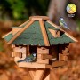 Sechseckiges Dobar Vogelhaus aus Holz mit grünem Bitumendach. Zwei Meisen fressen am Futterhaus.