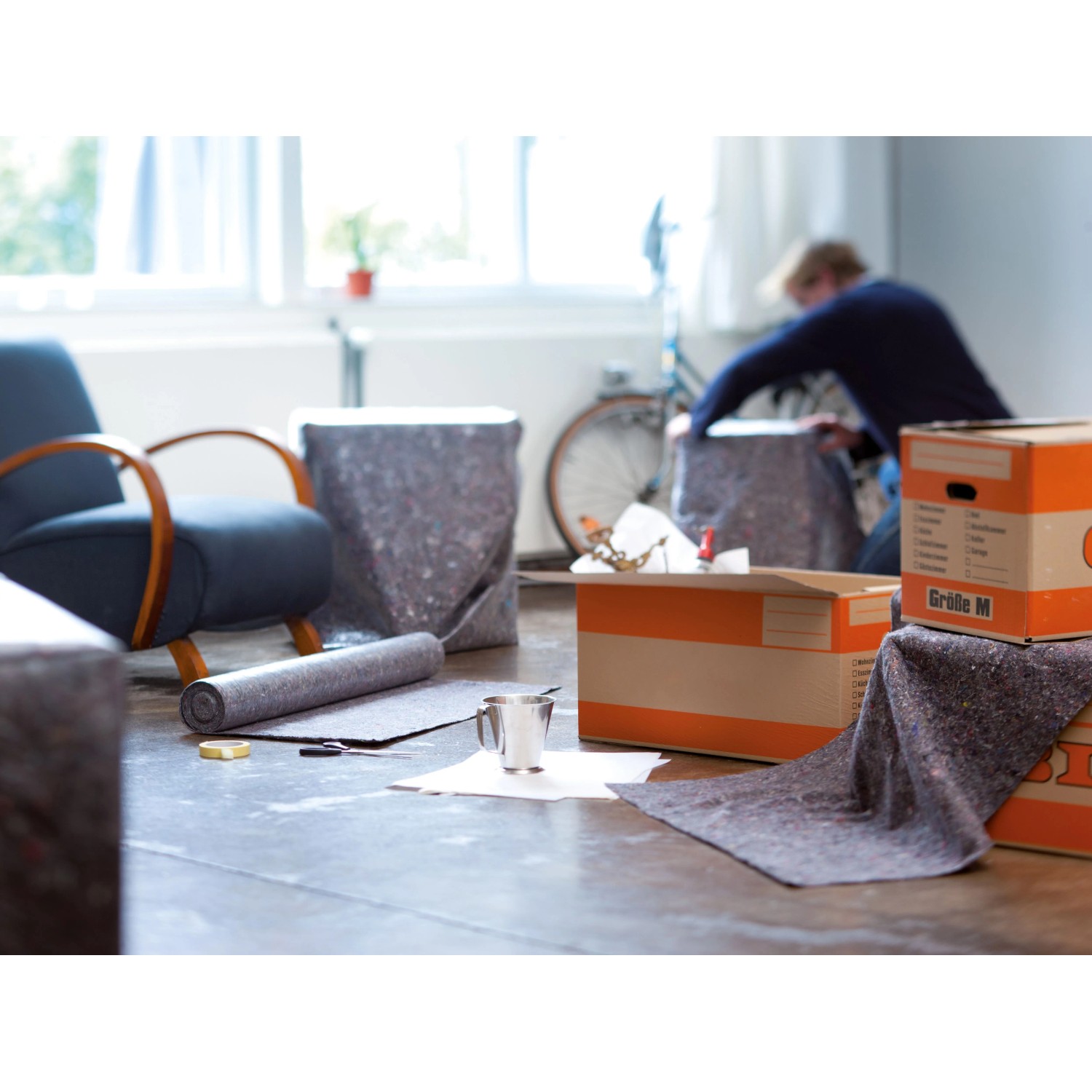 Graues Abdeckvlies schützt Boden und Möbel bei Umzug und Renovierung. Rutschfestes Abdeckmaterial in Nutzung.