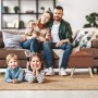 Brauner Relaxdays Hocker mit Stauraum, Kunstleinenbezug und Holzfüßen vor Familie im Wohnzimmer.
