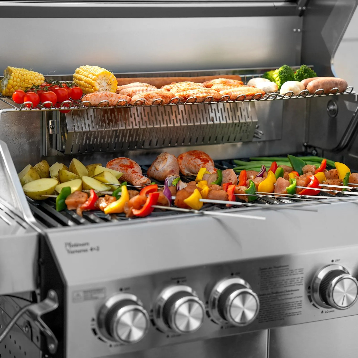 Taino Platinum Yamara 4+2 Gasgrill mit Speisen wie Gemüse, Fleisch und Mais auf dem Grillrost.