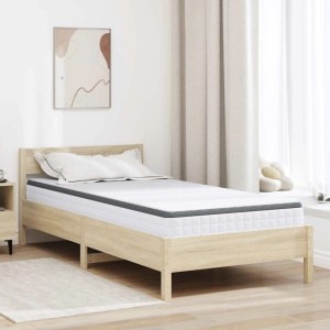 Weiße und graue Bonell Feder Matratze 100x200 cm auf hellem Holz-Bettgestell im Schlafzimmer.