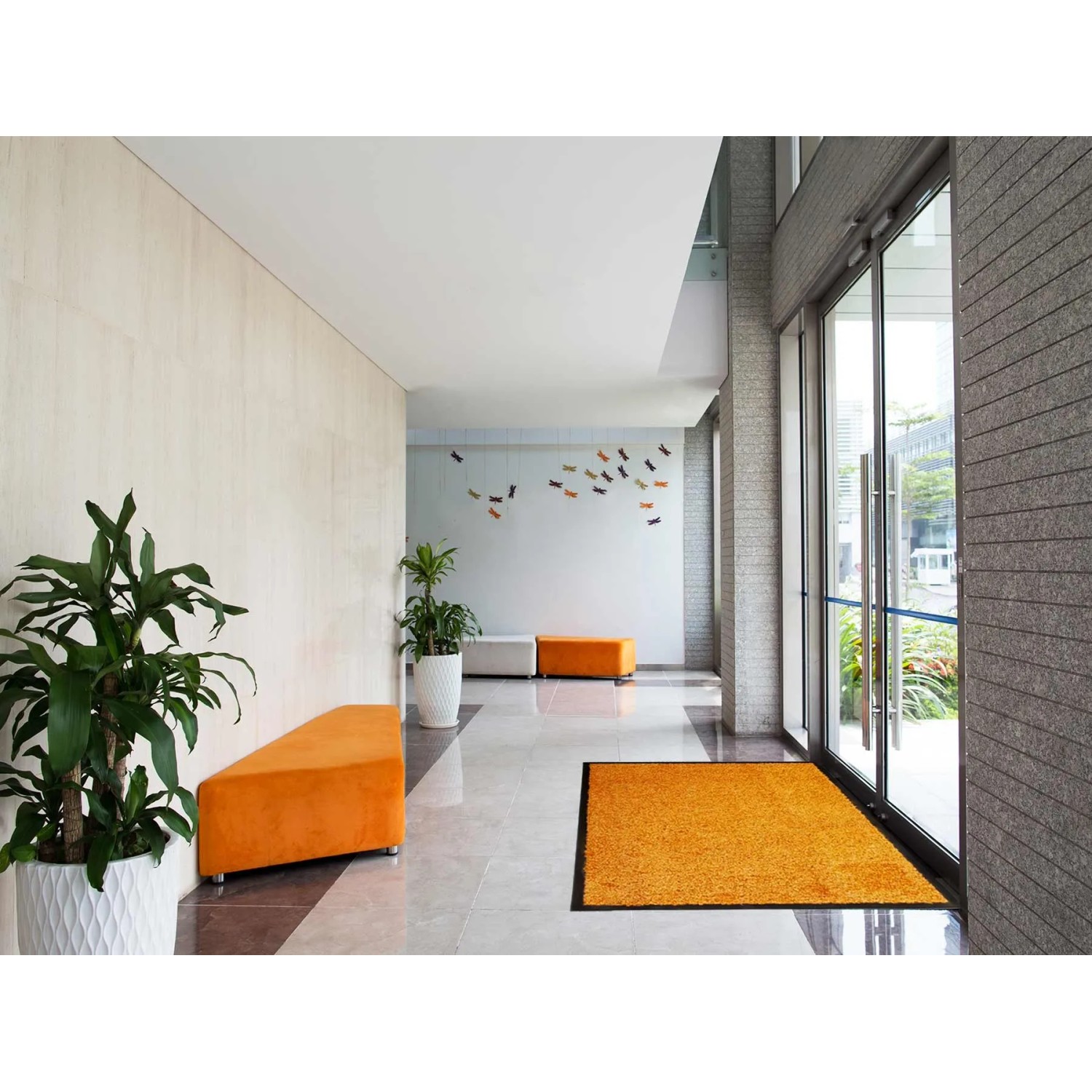 Orangefarbene Primaflor Schmutzfangmatte Clean 90x150 cm im Eingangsbereich.