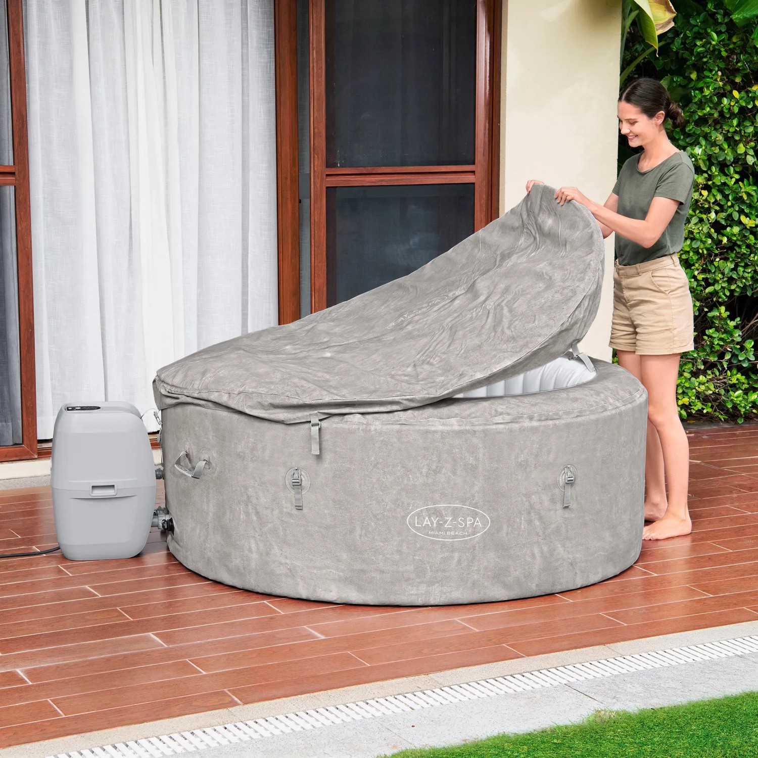 Bestway Lay-Z-Spa ECO Miami Beach AirJet auf Terrasse mit Frau beim Öffnen der Abdeckung.