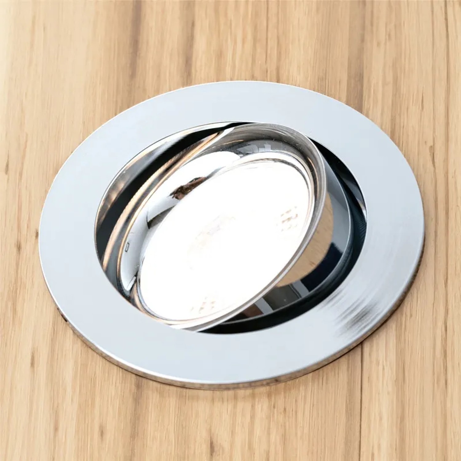 Dimmbares Orion LED-Modul GU10, 4,9W, warmweiß, in Chromfassung auf Holz montiert.