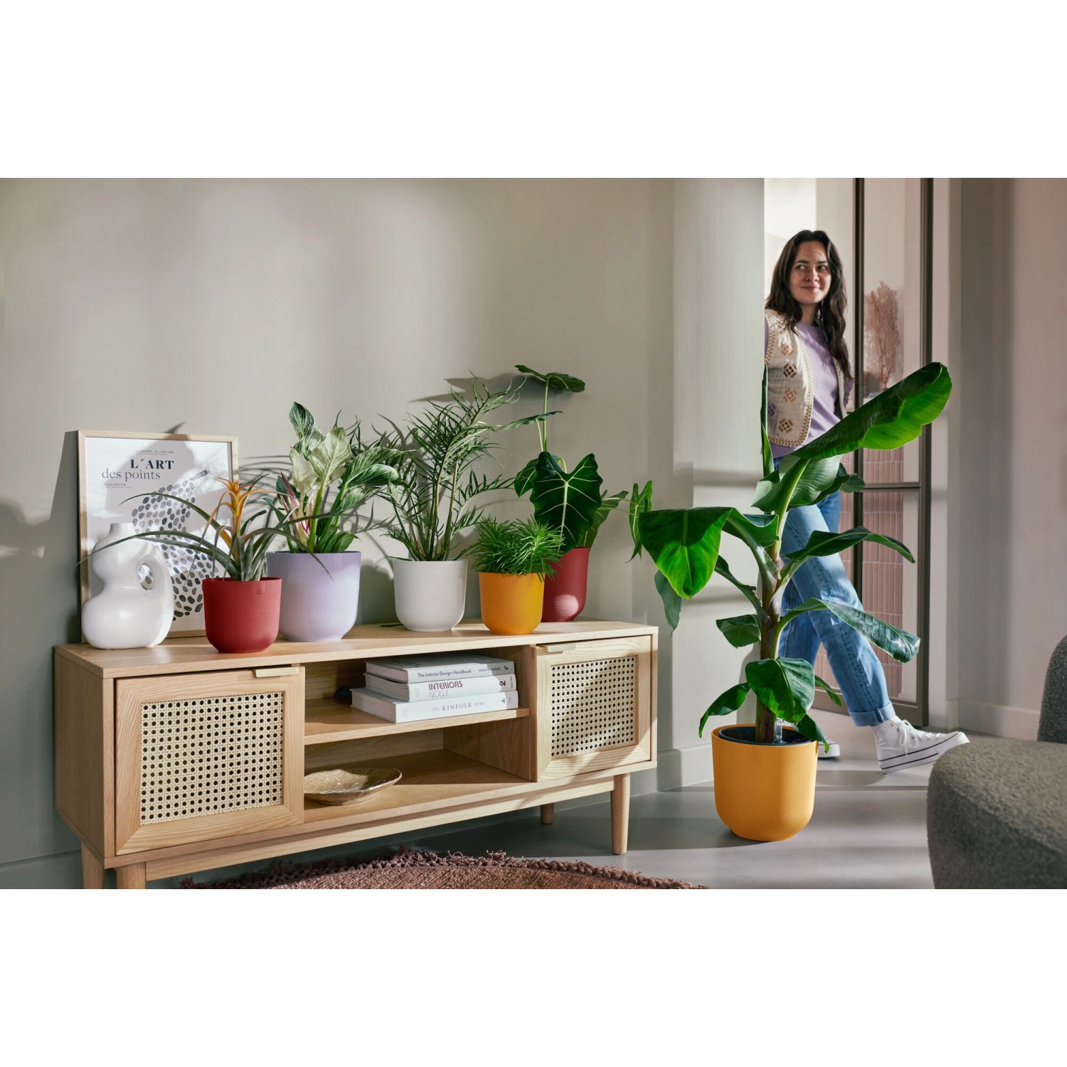 Verschiedenfarbige Elho Blumentöpfe Jazz auf einem Sideboard in einem Wohnzimmer.