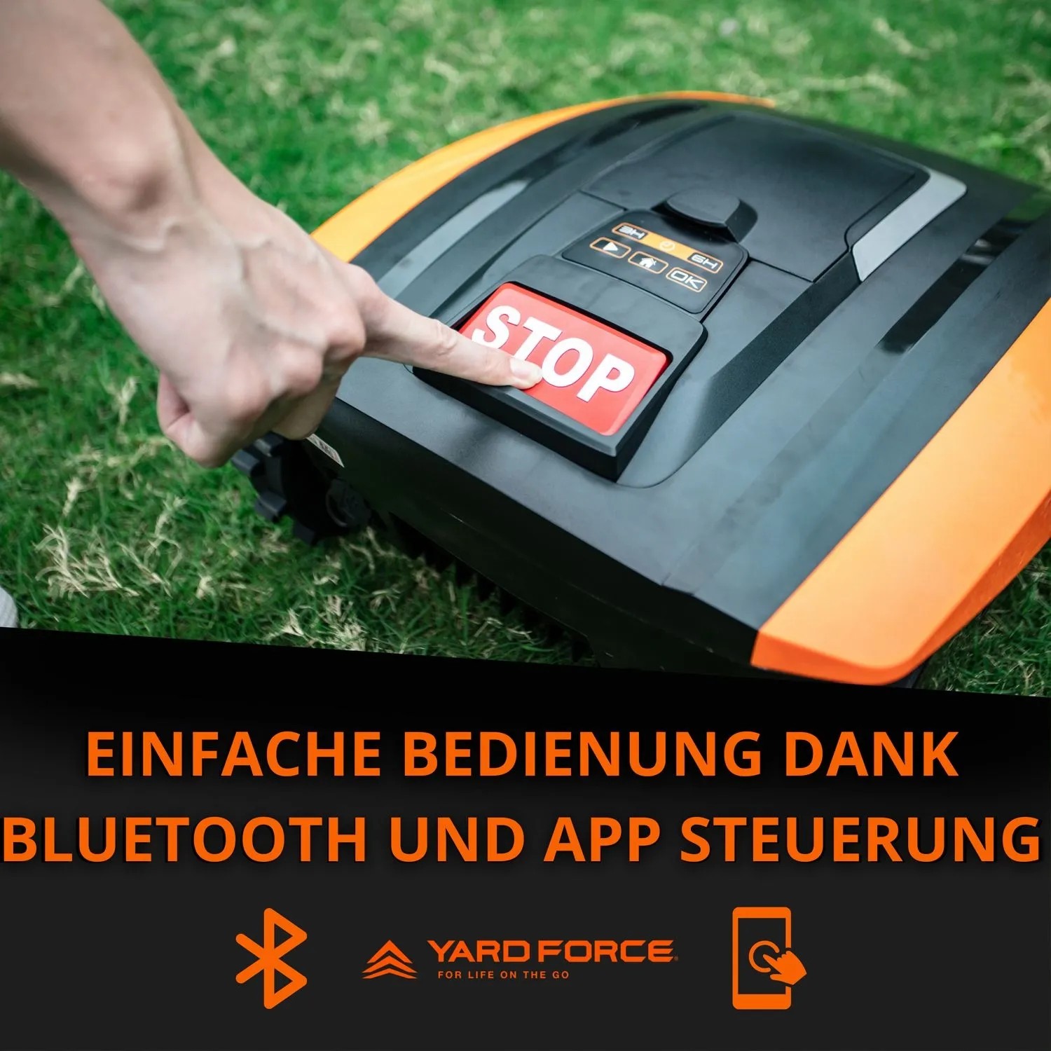 Hand drückt roten STOP-Knopf auf Yard Force Mähroboter. Einfache Bluetooth App-Steuerung für Rasenpflege.