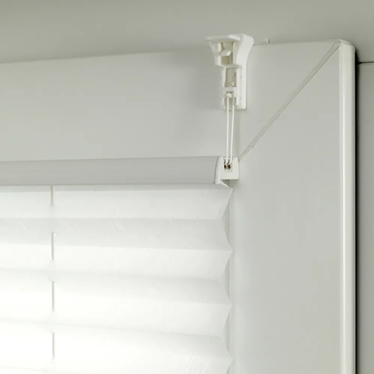 Detailaufnahme: Weißes Gardinia Plissee Bella Blätter, blickdicht, mit Klemmträger am Fenster.