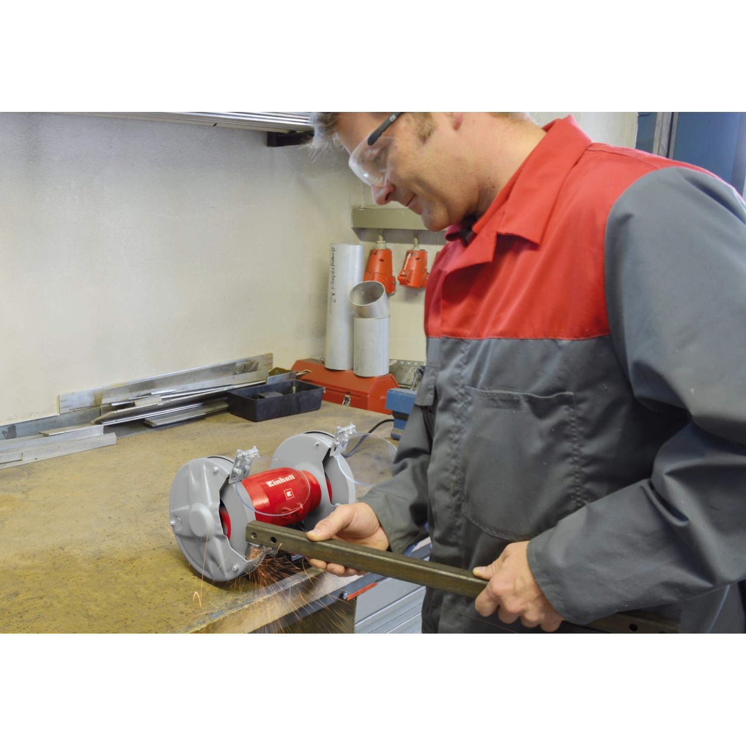 Einhell by kwb Schleifscheibe im Einsatz: Mann schleift Metall mit Doppelschleifer und Funkenflug.