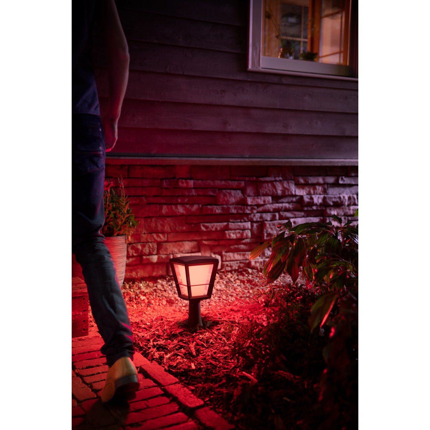 Philips Hue Econic LED-Sockelleuchte im Garten, farbig beleuchtet.