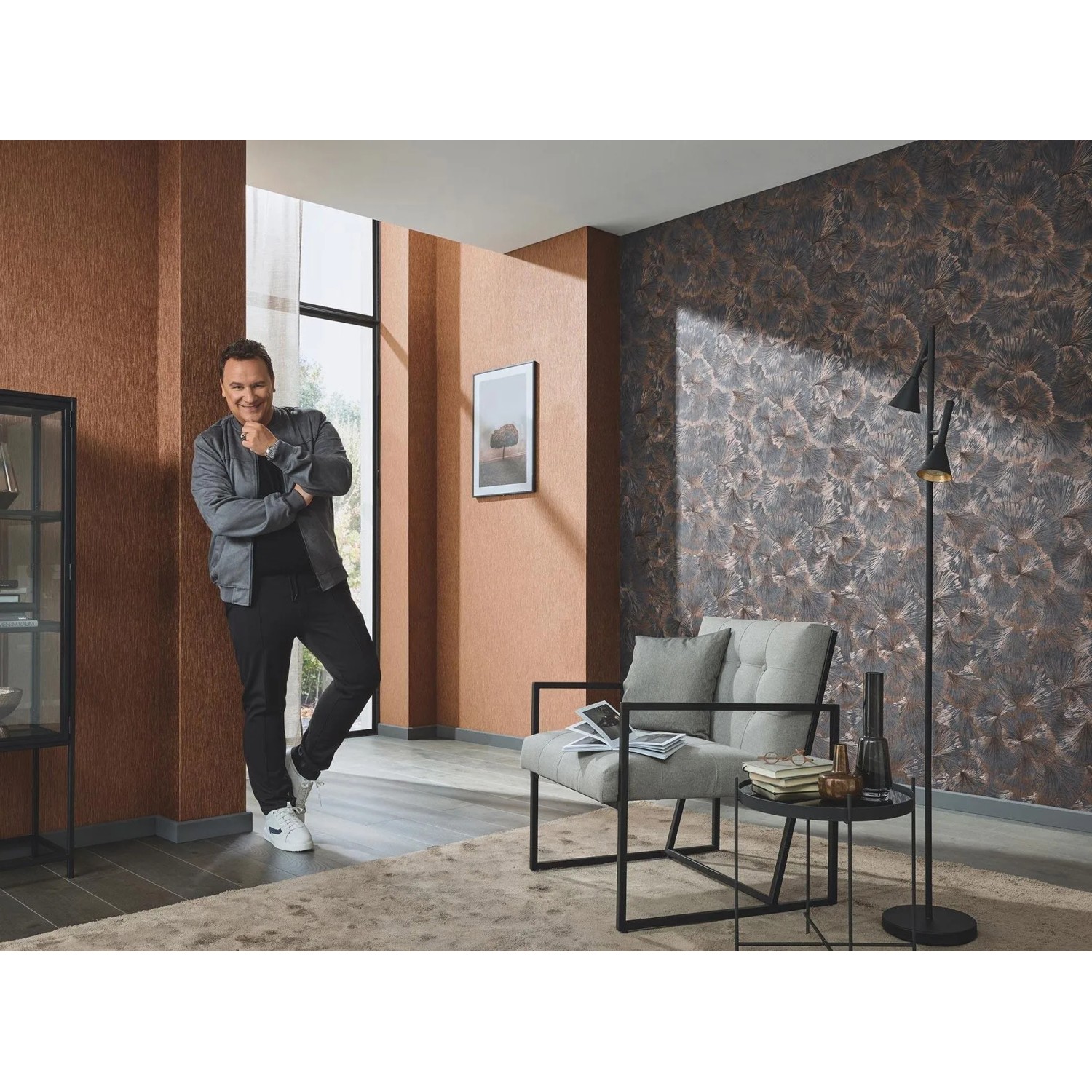 Moderne Vliestapete Neriah Copper mit grauem Dschungel-Palmenblattmuster und schimmernden Kupfer-Akzenten im Wohnzimmer.