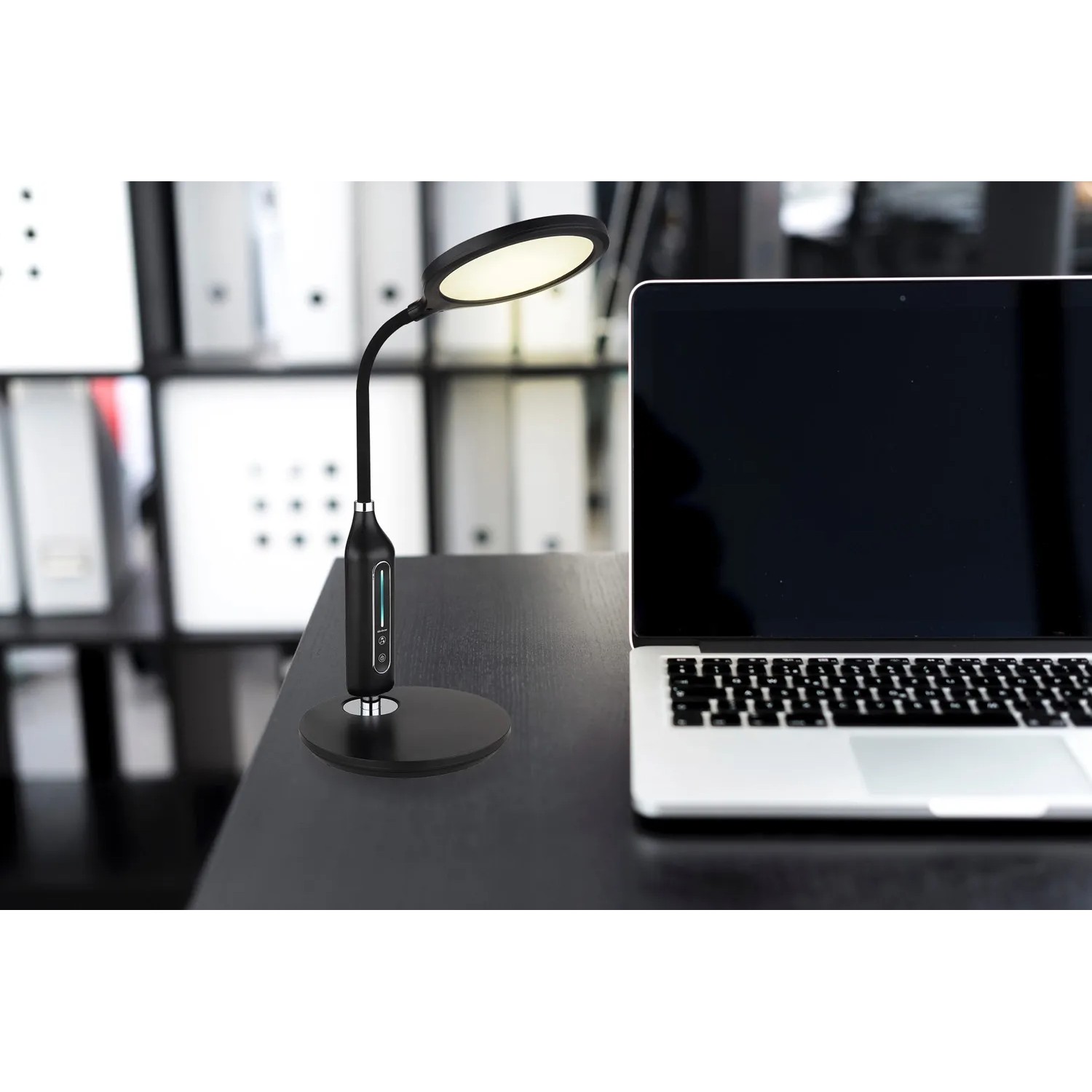 Schwarze LED-Tischleuchte Fruggy mit Flexarm und Touchdimmer auf Schreibtisch.