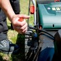 metabo Akku-Rasenmäher RM 36-18: Hand bedient roten Griff am Rasenmäher.