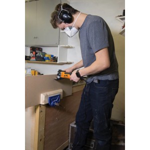 Mann arbeitet mit Triton Multifunktionswerkzeug an Werkbank. Multitool zum Sägen, Schleifen.