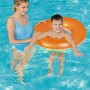 Kind mit orangem Bestway Schwimmring im Pool, betreut von Erwachsenem.