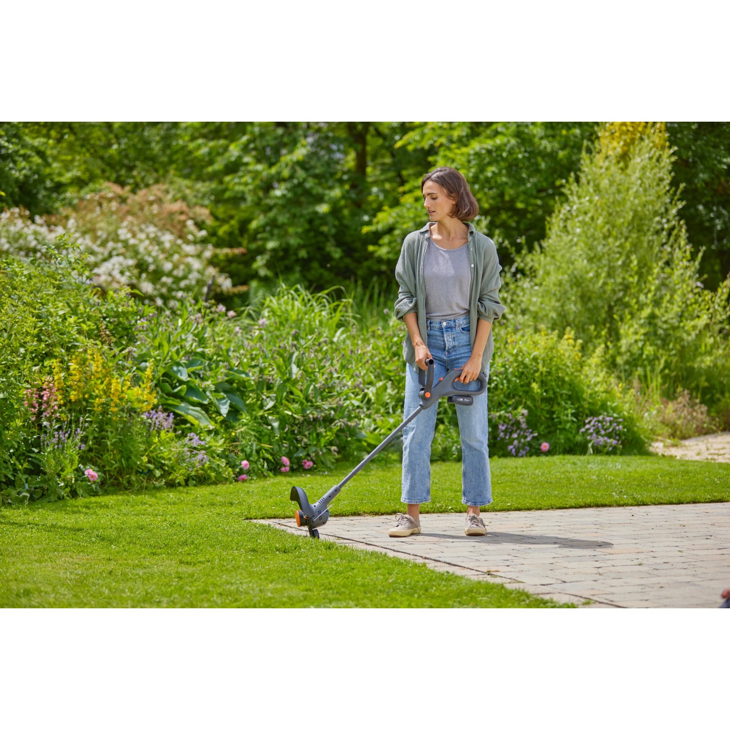 Frau trimmt Rasen mit Gardena Akku-Rasentrimmer EasyTrim 25/18V. Leicht und handlich.