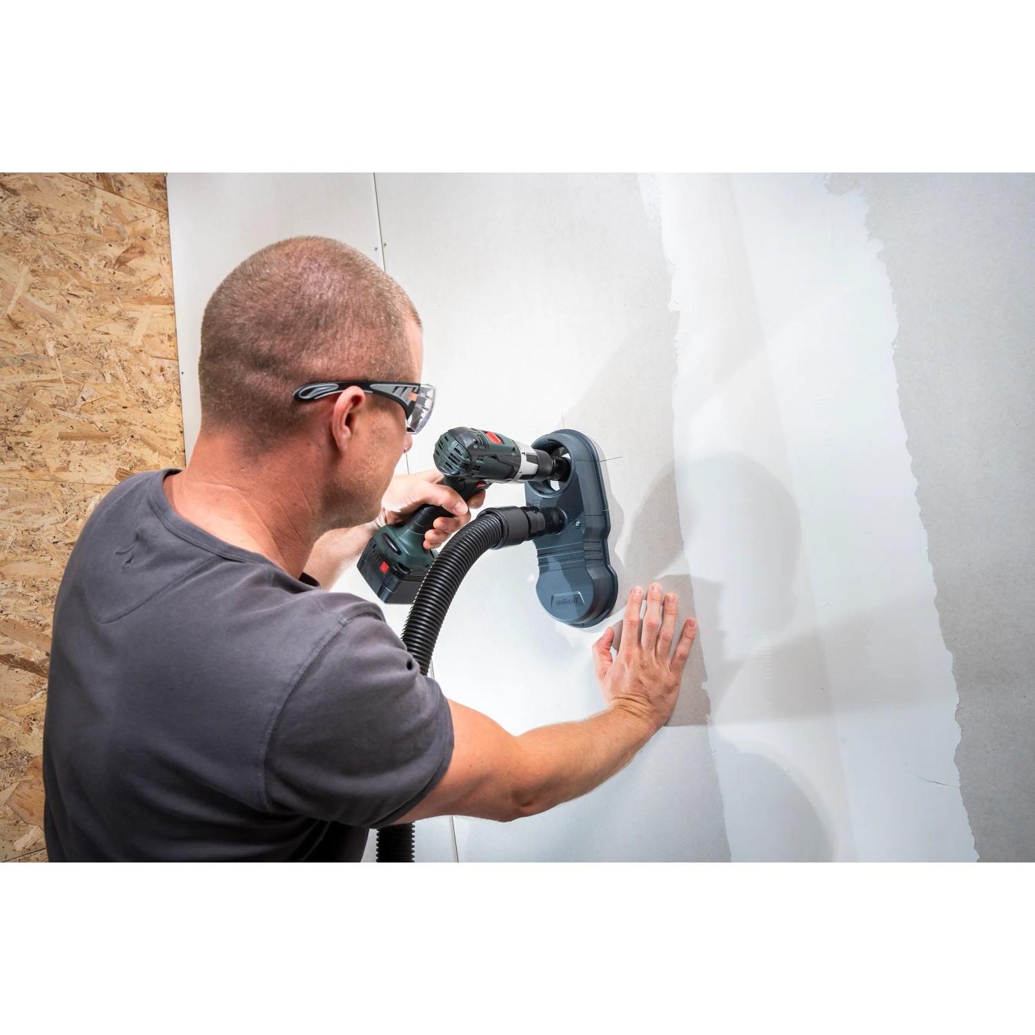 Wolfcraft Absaugsystem HSD 68/100 im Einsatz mit Bohrmaschine an Wand.