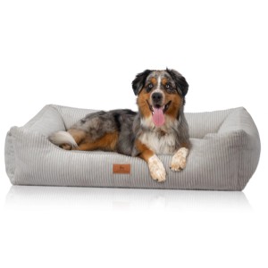 Hund liegt entspannt im hellgrauen Knuffelwuff Hundebett Olivia Cord XL (105x75cm).
