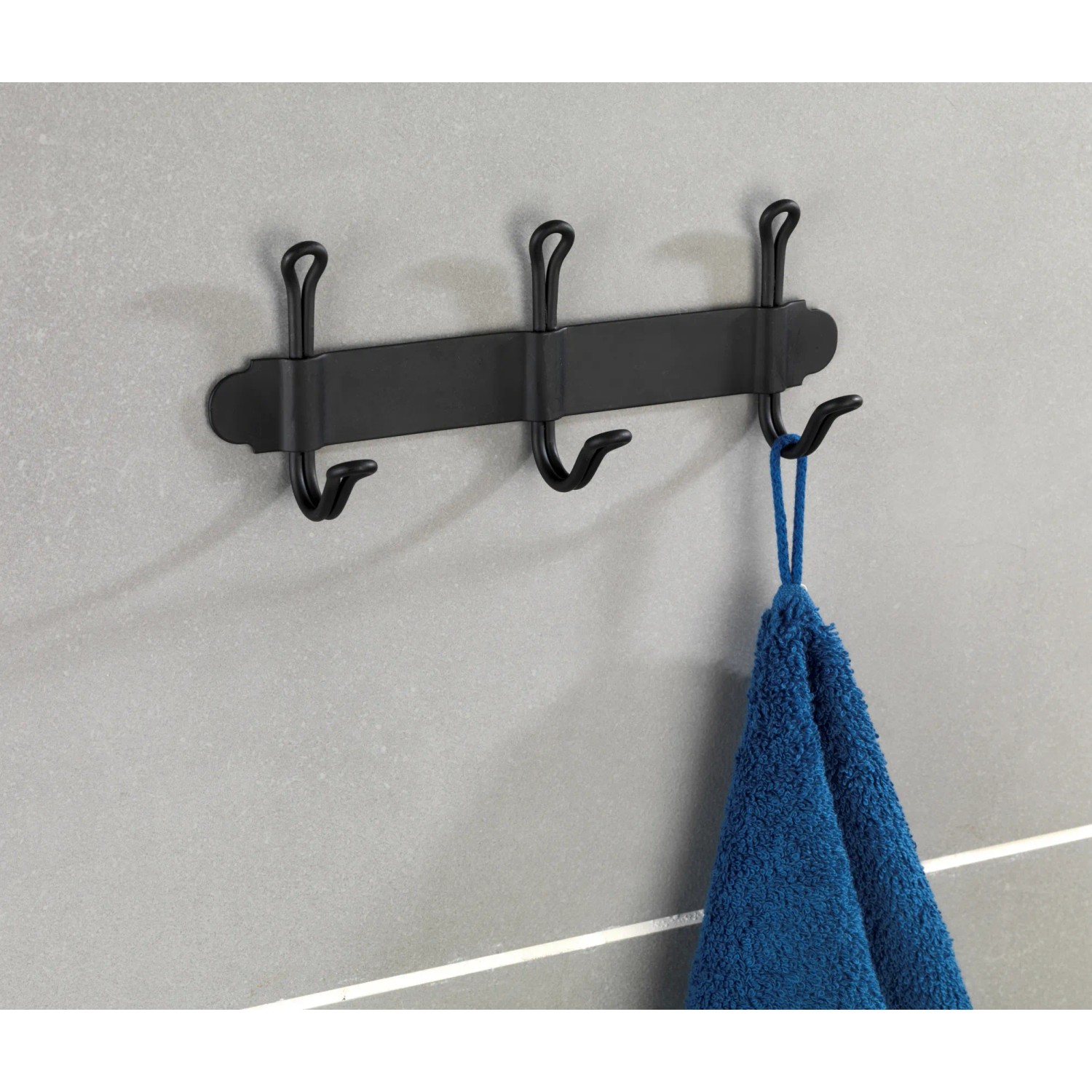Wenko Hakenleiste Nostalgie Trio, schwarz matt, mit drei Haken und blauem Handtuch an grauer Wand.
