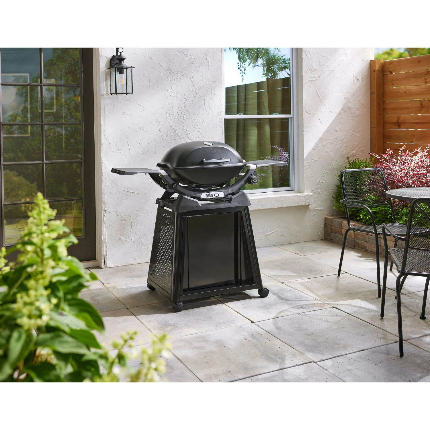 Schwarzer Weber Gasgrill Q2200N mit Rollwagen und einem Brenner auf einer Terrasse.