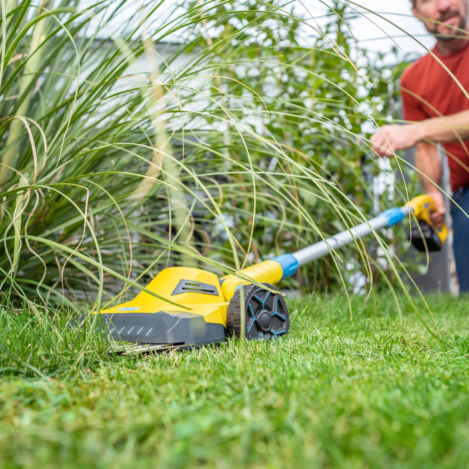 Gelber Gloria Akku-Rasentrimmer Finecut 18 V im Einsatz zum Rasenkantenschneiden.