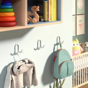 Drei weiße SOTECH FARA Garderobenhaken aus Stahl an hellblauer Wand im Kinderzimmer, mit Pullover und Rucksack.