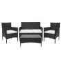 Schwarze 4-teilige Poly-Rattan Lounge-Garnitur mit creme-farbenen Kissen und Tisch mit Glasplatte.
