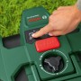 Detailaufnahme: Hand bedient Bosch Mähroboter VISIMOW18V-100. Fokus auf Bedienfeld mit Start/Stop Knopf.