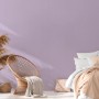 Michalsky Living Vliestapete Uni Lila, Tapete im Wohnraum mit Sessel und Bett.