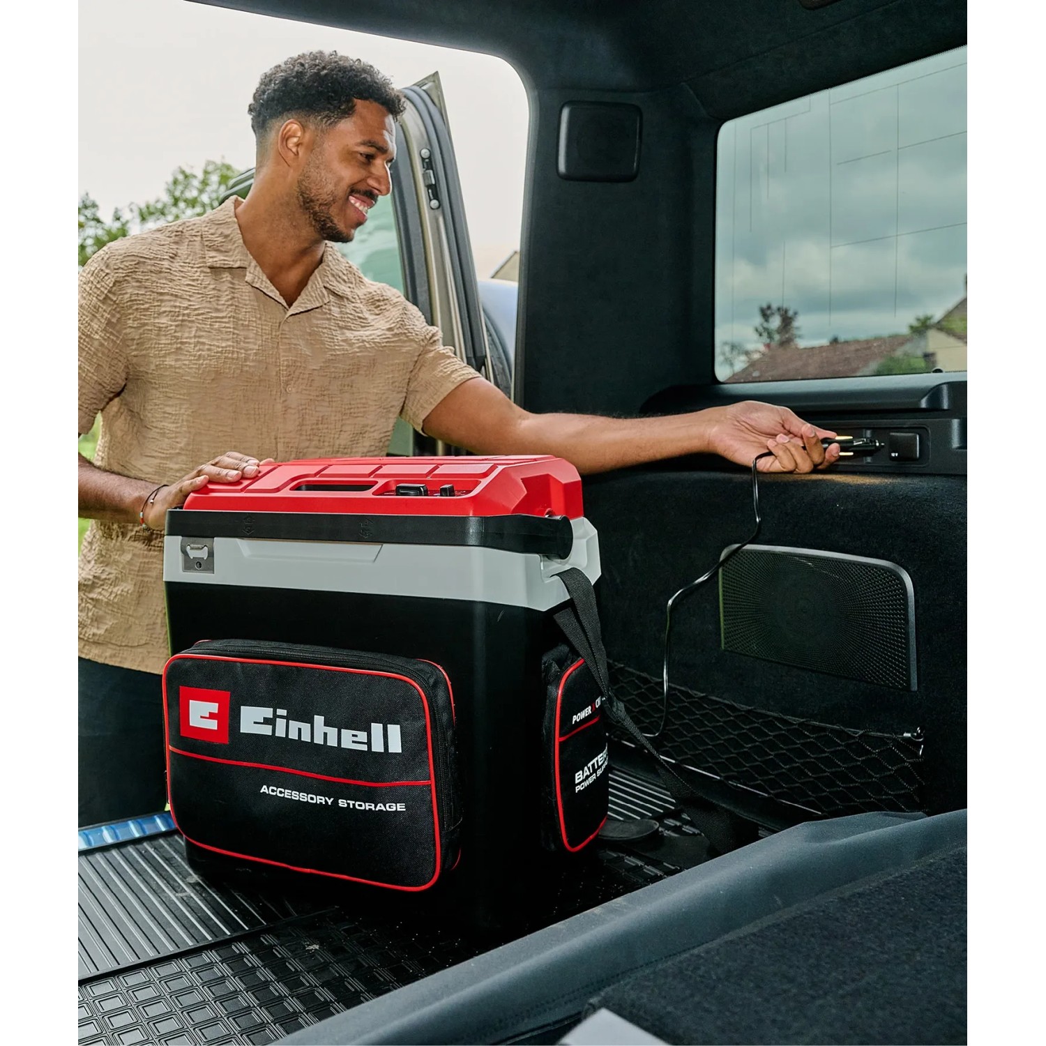 Einhell Akku-Kühlbox TE-COL 18/27 Li-Solo im Auto, mit Zubehör-Tasche und Tragegurt.