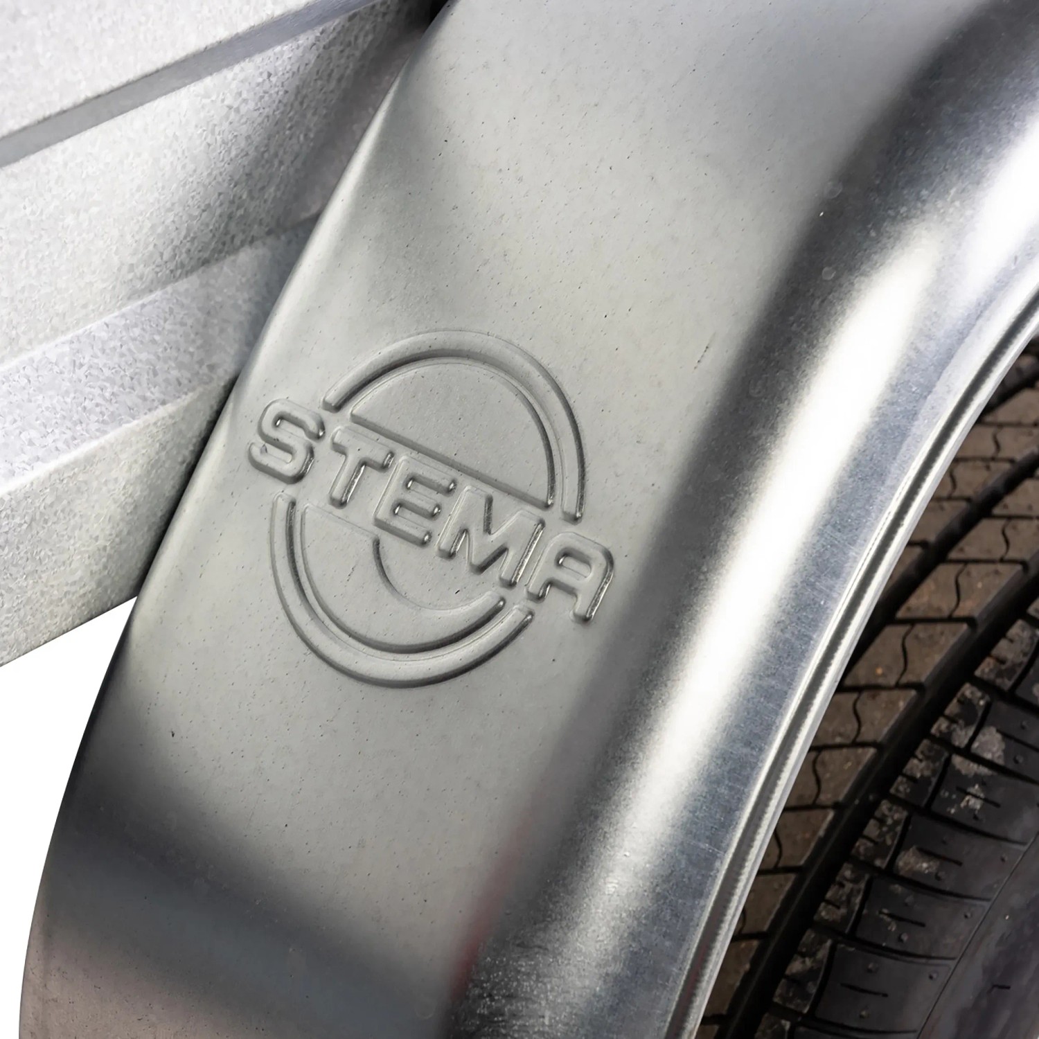 Detailaufnahme: Stema Anhänger Variolux 550 Radkasten mit Stema Logo.