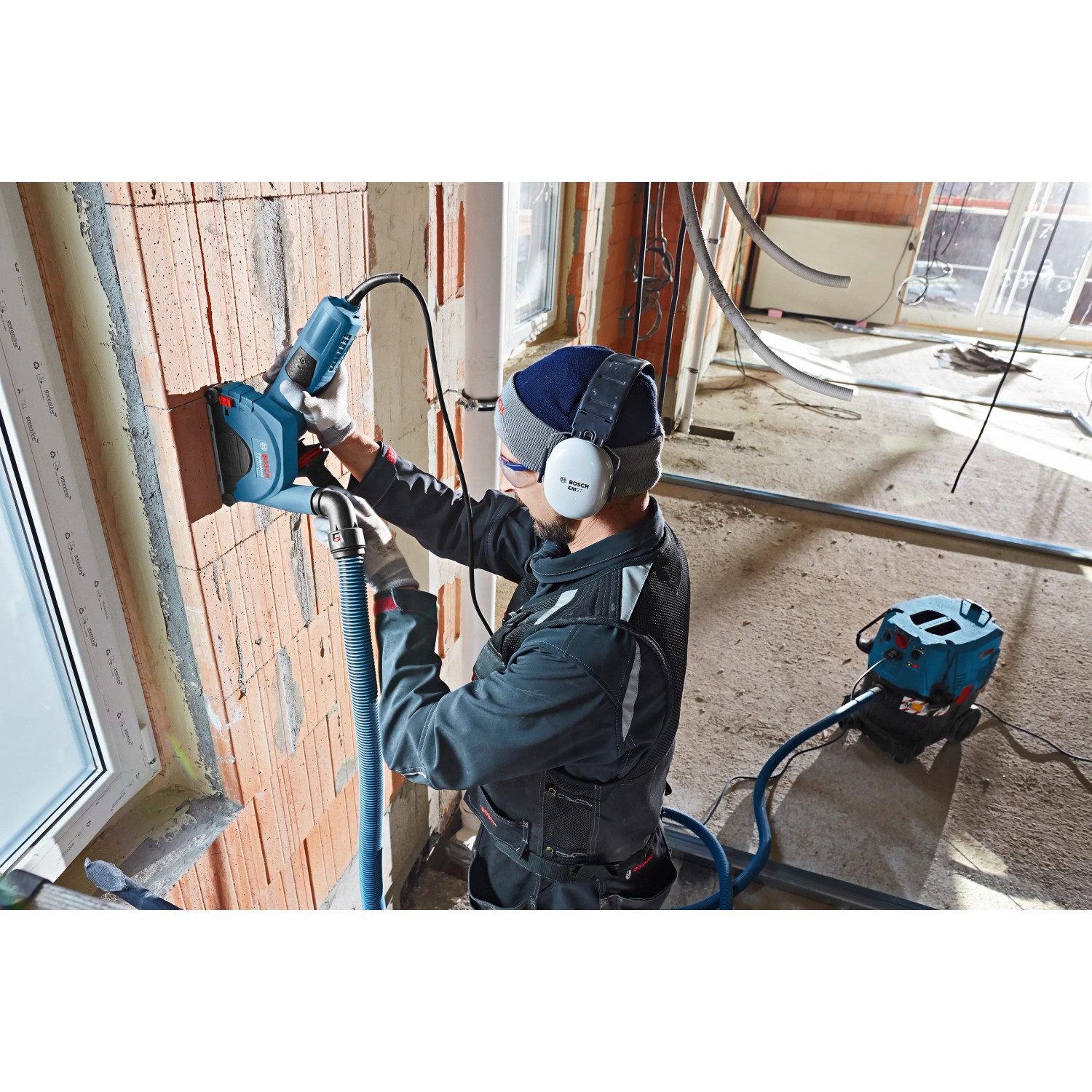 Bosch GDE 230 FC-S Staubabsaugung für Winkelschleifer im Einsatz an einer Ziegelwand.