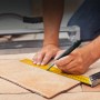 Hand markiert Fliese mit Baumarker Dry Profi und Lineal. Prüfwerkzeug für präzise Markierungen.