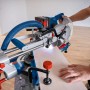Bosch Professional GCM 18V-216 D Akku-Kapp- und Gehrungssäge in Aktion mit Laserlinie.