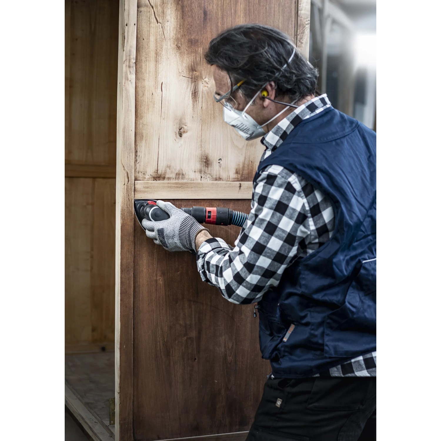 Mann schleift Holz mit Bosch Expert Deltaschleifer und C470 Schleifblatt K240.