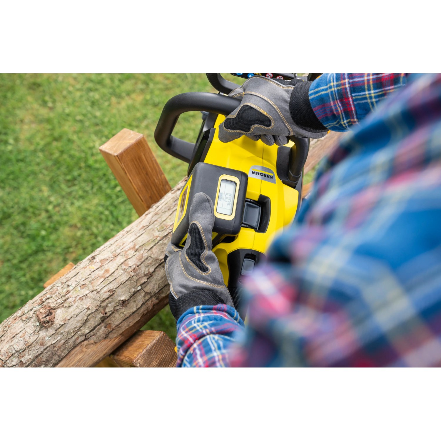 Gelbe Kärcher Akku-Kettensäge CNS 18-30 Battery im Einsatz beim Sägen von Holz.
