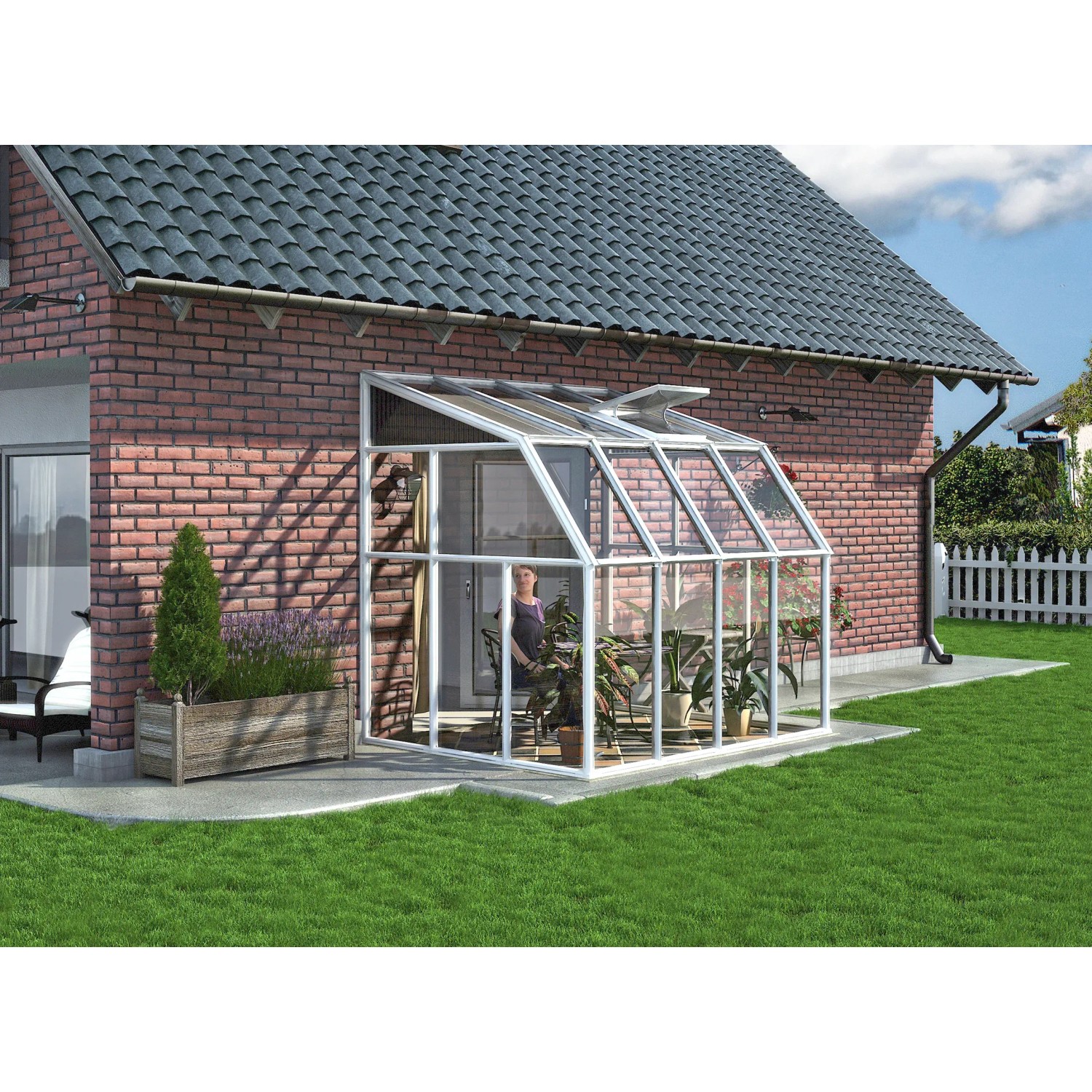 Weißes Palram Canopia Gewächshaus Sun Room (262x201 cm) am Haus mit Pflanzen.