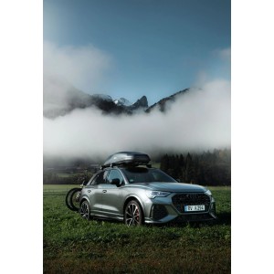 Atera Dachbox Casar M Lava 360 l Schwarz auf Auto montiert, mit Fahrradträger im Grünen.