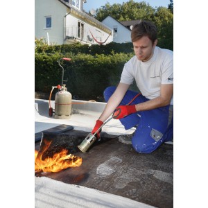 Mann arbeitet mit Rothenberger RoMini Anwärmbrenner (Lötgerät) auf einem Dach.