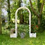 Weißer KHW Rosenbogen mit Pflanzkästen im Garten, dekoriert mit Blumen.