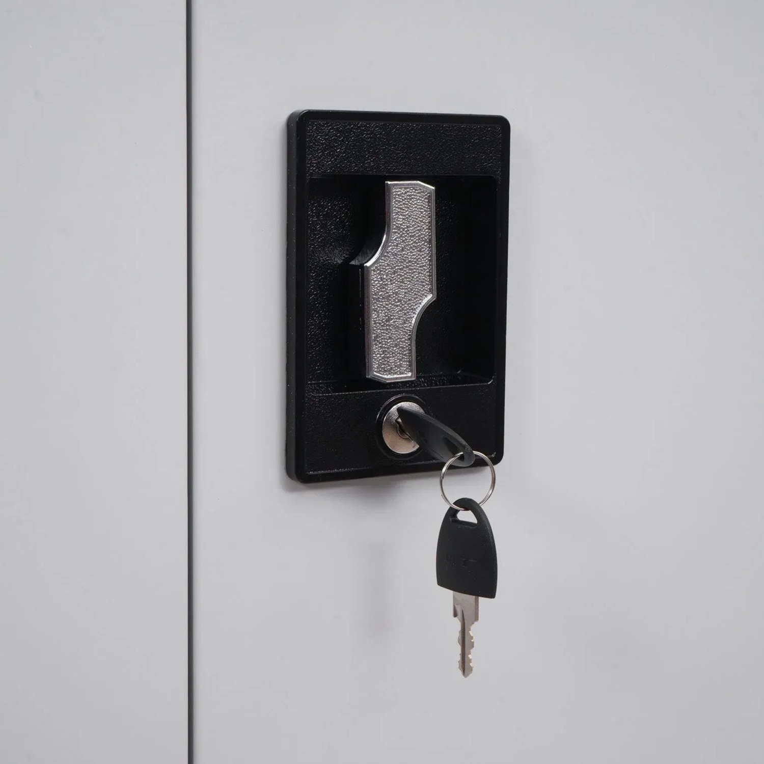 Zylinderschloss mit Schlüssel am hellgrauen Aktenschrank. Sicherer Büroschrank für Dokumente.