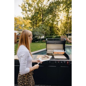 Frau hält Enders Pizzaschaufel mit Pizza am Grill. Große, silber-schwarze Aluminiumschaufel für Grillutensilien.