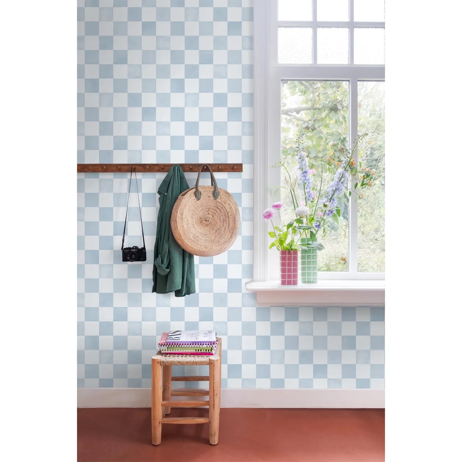 ESTAhome Vliestapete mit blau-weißem Karomuster an einer Wand, daneben Fenster und Deko. Stilvolle Wandgestaltung.