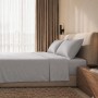 Hellgraues Baumwoll-Perkal Bettwäsche-Set auf einem modernen Bett mit Kissen und Kopfteil; 120 cm.