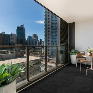 Anthrazit Rasenteppich Comfort (1,33x8m) auf Balkon mit Stadtblick. Kunstrasen für Terrasse und Outdoor.
