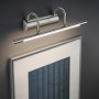 LED-Bilderleuchte Cuadro in Nickel matt über einem Bild. Wandlampe für akzentuierte Beleuchtung.