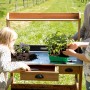 WONDERMAKE Pflanztisch auxilium1 aus Kirschbaumholz mit Kindern beim Pflanzen.