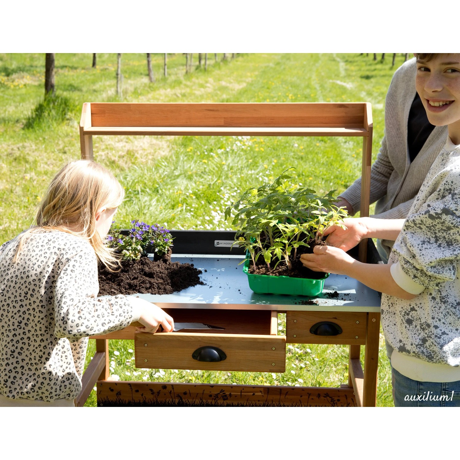 WONDERMAKE Pflanztisch auxilium1 aus Kirschbaumholz mit Kindern beim Pflanzen.