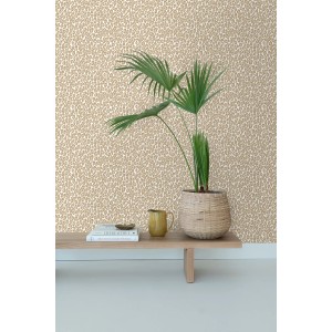 Beigebraune Vliestapete mit Leopardenmuster an einer Wand, dekoriert mit Pflanze und Holzbank. Stilvolle Wandgestaltung.